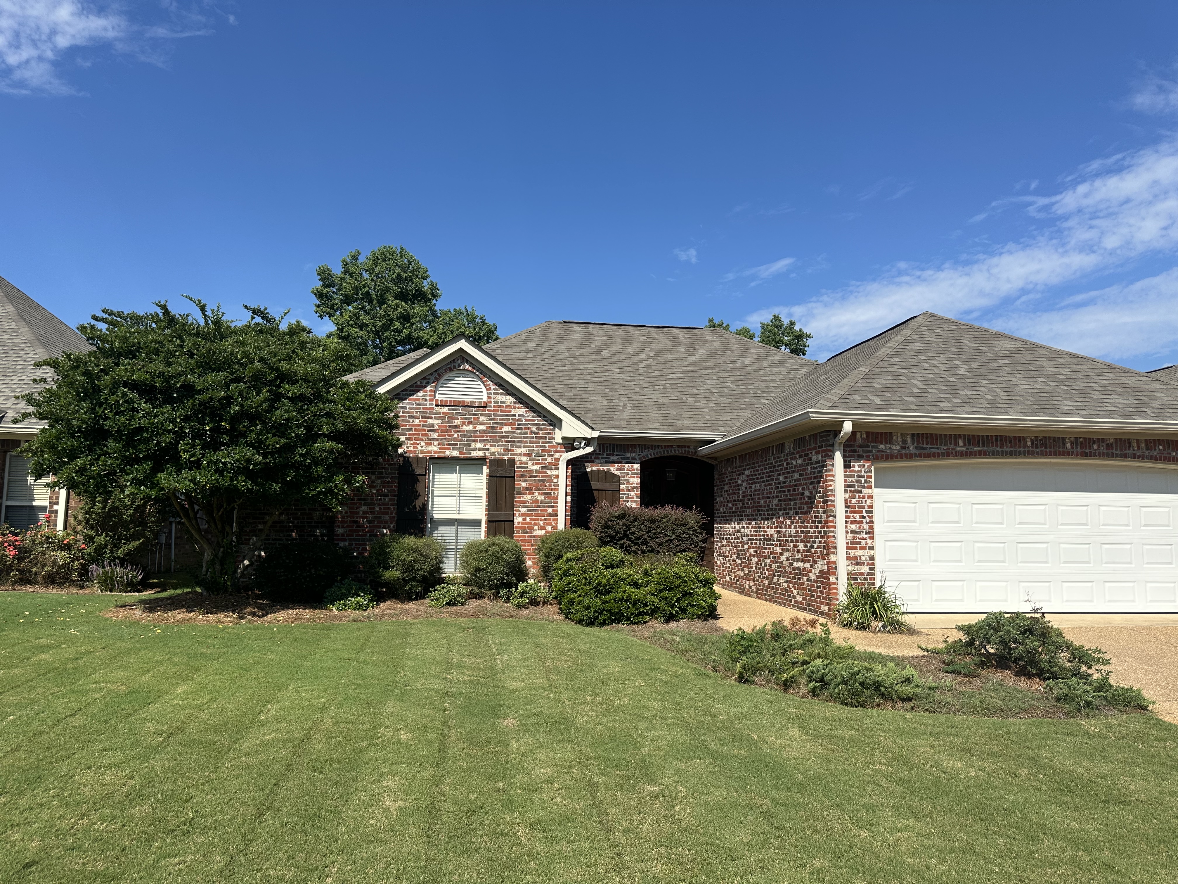 Striped lawn at brick home